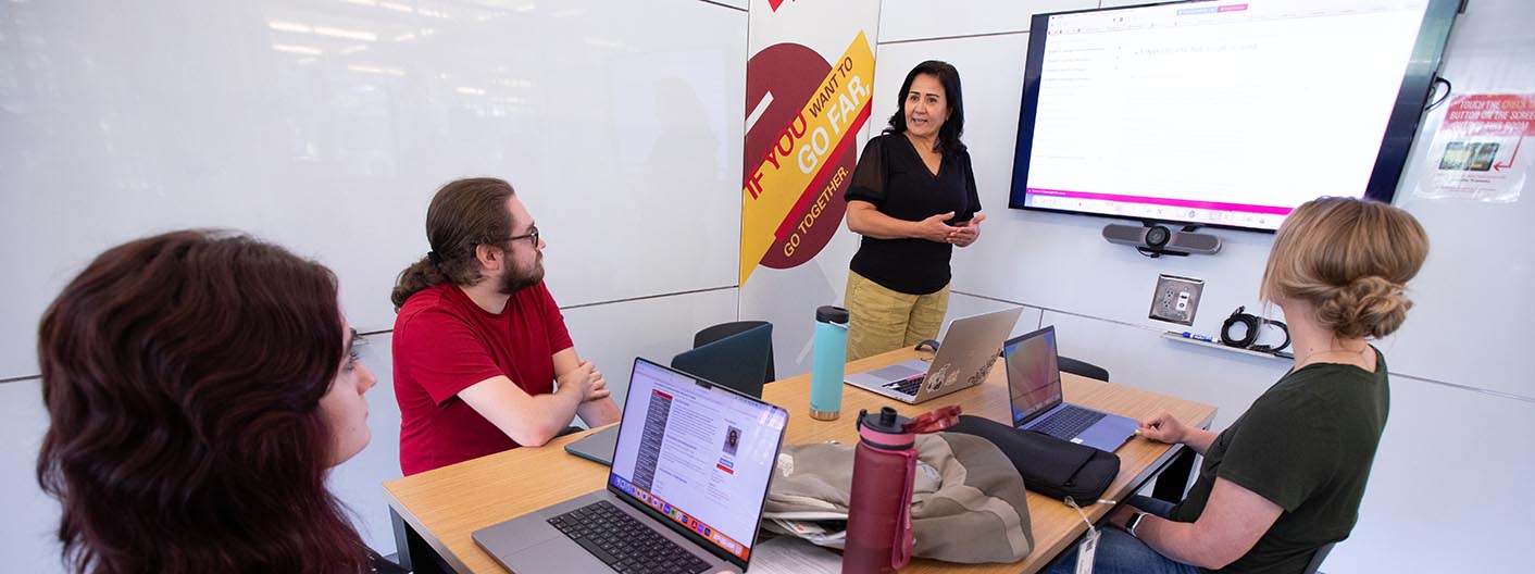 A four-person group works in a study room at Parks Library.