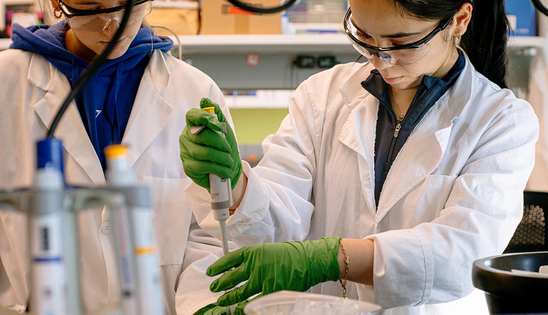 Two lab researchers work on extraction and testing.