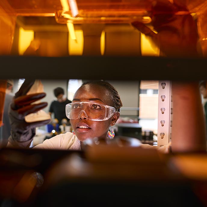 A student scientist examines a sample in the lab.
